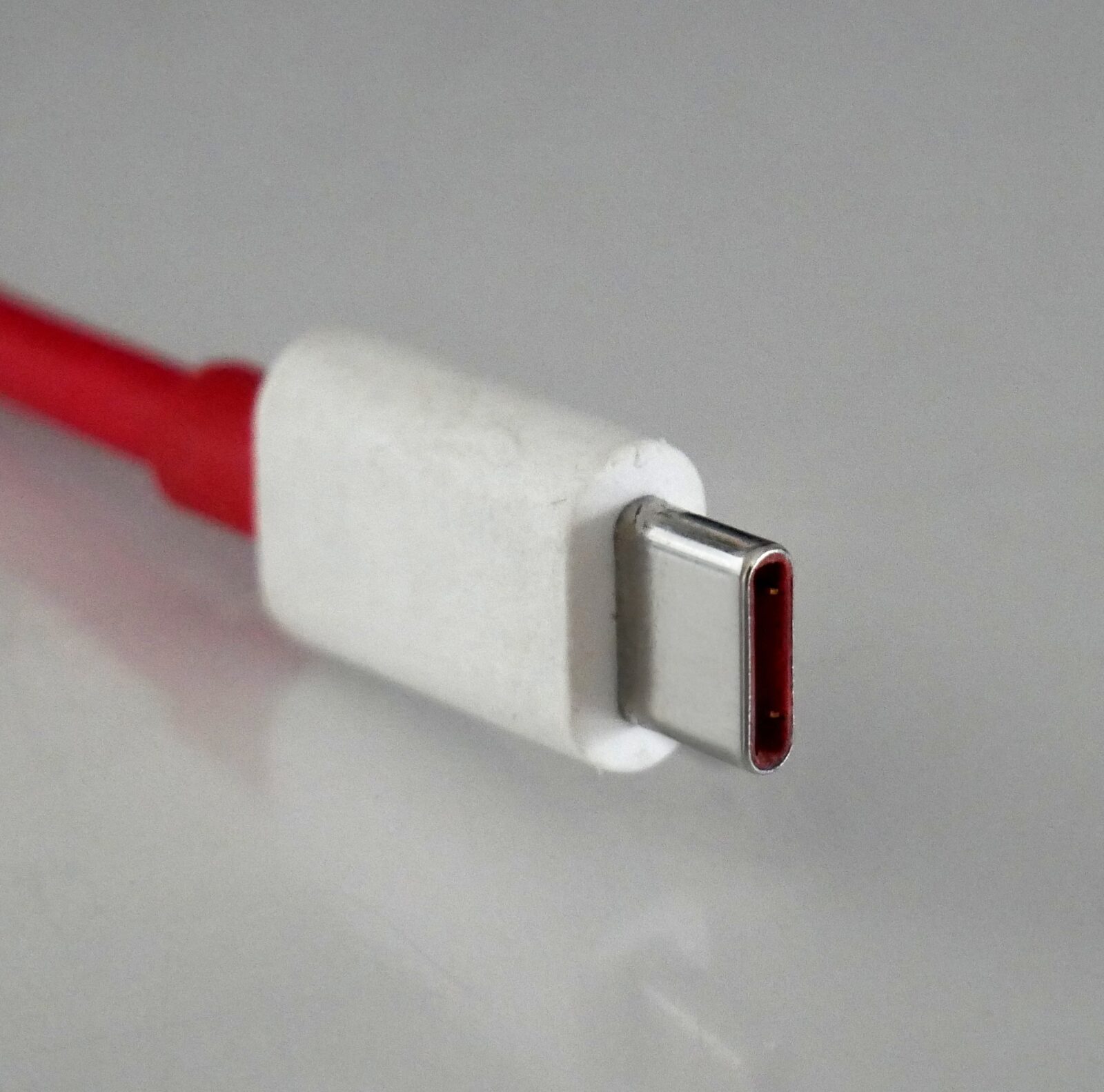 빨간 케이블 끝의 타원형 USB-C 금속 플러그